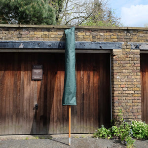 Parasol leaning against a garage