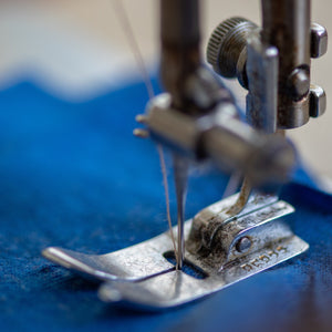 sewing machine sewing a parasol with blue fabric