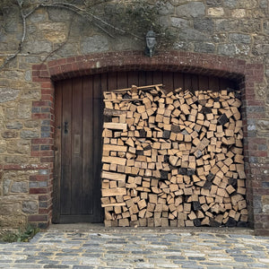 Chopped wood stacked outside a garage